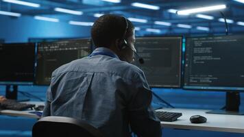 IT support expert in server room talking on headphones with admin about equipment storing datasets. Employee remotely chatting with specialist to mend data center racks doing computational operations photo