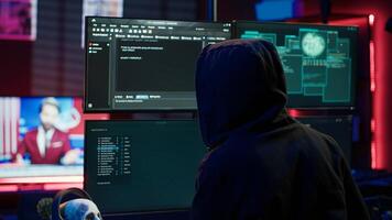 Hacker coding, developing zero day exploit undetectable by antivirus software installed on systems. Rogue programmer in apartment building script able to trick firewalls, camera A photo