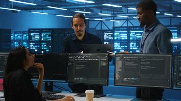 Man inspecting server farm, reading paperwork, following inspection checklist, talking with employees. Supervisor doing checkup in data center workplace, verifying reports files photo