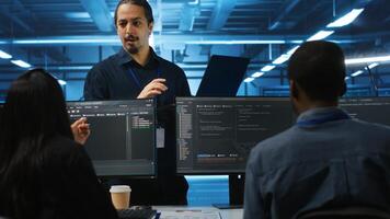 Manager and IT support specialists working together, supervising server rows in computer network security data center. Supervisor and multiethnic employees overseeing supercomputers photo