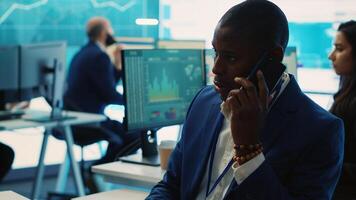 Business administrator discussing with the investors on phone call, reviewing key performance indicators during annual analysis. Manager works on data management, enterprise workflow. Camera A. photo