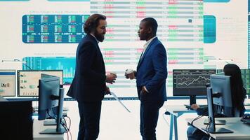 General director discussing with an investor to increase funding for a project, presenting performance metrics and annual data on a big screen. Business associates share strategies. Camera A. photo