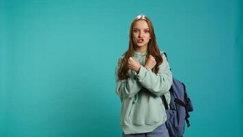 Assertive woman shows letter X with arms crossed, staying in warrior stance, showing fierceness. Firm young person using negative body language to signal rejection, studio background, camera B photo