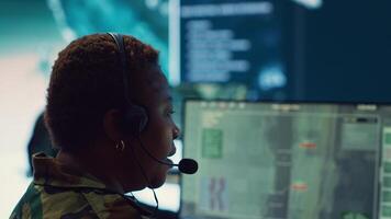 Woman army officer operates on gps surveillance footage to gather crucial information about enemy plans. Operator examines a satellite world map to provide support to field troops. Camera A. photo