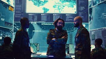 Army superior officers creating an attack plan using a hologram to gather real time information, working together to ensure national safety in a command center. Military operations. Camera B. photo