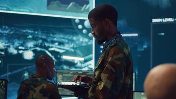 Military sergeant targeting enemy vessels on a gps satellite world map, operating from army power base monitoring room. Officer studies defense tactics on a tablet, command center. Camera A. photo