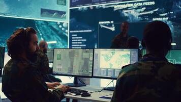 Commander communicating with allied forces and transmitting data from surveillance footage, coordinating joint operations and strategies to accomplish mission. Satellite radar operator. Camera B. photo