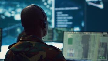 Army personnel applying national safety protocols by verifying all ships anchoring in the coastal ports, using radar surveillance on big screen in military command post. Federal operations. Camera A. photo