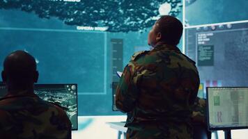 Woman colonel handling a special operation with big data in monitoring room, providing important satellite information to her crew in command post. Targeting enemy power base. Camera A. photo