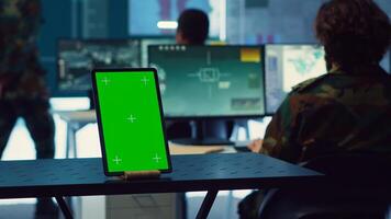 Isolated greenscreen display running on a tablet in military power base, soldiers follow surveillance footage to stay alert in case of a hostile attack. Satellite system for reconnaissance. Camera A. photo