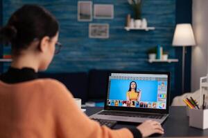 Student retouching photos on laptop. Freelancer photo editor working from home office. Creative artist using editing software to retouch photographs. Graphic designer creating digital art.