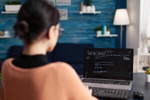 Freelancer programming software on laptop. Programmer working remote from home office. Code tester debugging on laptop using keyboard. Student developer typing data on screen. photo
