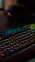 Close up of professional keyboard with RGB lighting prepared for streaming online tournament, display with first person shooter playing on it. Gaming studio of esport game with powerful computer photo