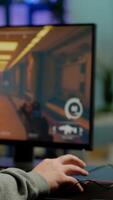 Close up of RGB powerful computer gamer rig with first-person shooter game on screen, pro cyber man participating at online esports championship. Player performing at gaming tournament in cyberspace photo
