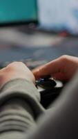 Close up on hands of game r playing using wireless joystick in cyberspace sitting on gaming chair. Cyber man holding controller performing space shooter games at online esports championship photo