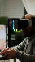 Videogame player with VR headset raising hands after winning space shooter competition. Professional pro gamer playing online games with new graphics on powerful computer from gaming room photo
