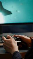 Closeup of competitive woman player holding joystick playing space shooter games at powerful computer late night. Professional gamer using wireless controller for online gaming championship photo