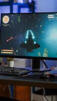 Addicted lady playing space shooter game using headphones ,wireless joystick and RGB powerful personal computer. Cyber gamer with headset and joypad performing virtual games at gaming championship photo