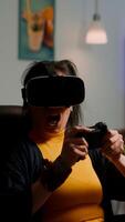 Videogame player with vr goggles raising hands after winning space shooter competition wearing headset dancing. Professional pro cyber woman playing online game with new graphics on powerful computer photo