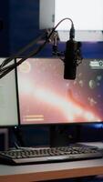 Empty streaming home studio equipped with professional equipment during online tournament late at night in gaming studio. Pro streamer playing space shooter game having esport championship photo