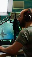 Pro cyber man streaming videogame, reading on stream chat and playing space shooter on RGB powerful computer. Streamer sitting on gaming chair playing game during online esports tournament. photo