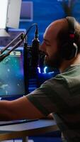 Man streamer cyber checking sound at mixer performing space shooter game on RGB powerful computer talking with players on stream chat and microphone in gaming competition. Player man streaming photo
