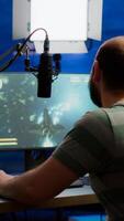 Streamer cyber performing space shooter game on RGB powerful computer talking with players on stream chat and microphone during professional competition. Player man streaming in home studio photo