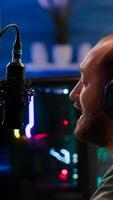 Streamer man talking into microphone with other players during space shooter tournament. Online streaming cyber performing games competition using professional headphones and stream chat photo