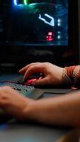 Close up of player hands using RGB keyboard in gaming home studio streaming space shooter game. Digital gamer using professional equipment for game competition late at night in living room photo