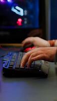 Close up of streamer typing at RGB keyboard playing space shooter videogame. Pro cyber man using mixer sound in gaming home studio for online esports competition on professional powerful computer photo