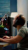 Happy streamer man winning space shooter online competition talking at professional microphone in gaming home studio. Gamer playing online games with streaming chat open during tournament photo