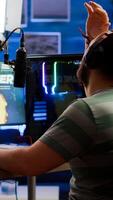 Videogame streamer losing online videogame competition wearing professional headset talking on stream chat. Sad gamer using powerful computer for gaming tournament late night playing space shooter game photo