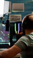 Excited streamer with headphones winning important online esport competition of space shooter playing on powerful computer. Professional pro gamer streaming videogames using professional microphone and headset photo