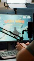 Entusiastic man gamer streamer wining space shooter games holding joystick playing on professional RGB keyboard and talking on stream chat. Pro cyber using microphone in gaming tournament photo