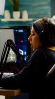 Focused streamer playing shooter game for virtual competition using professional headphones. Online streaming cyber performing during gaming tournament using powerful PC with RGB and stream open chat photo