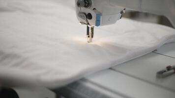 Capturing a detailed shot of a sewing machine working on fabric in a textile factory video
