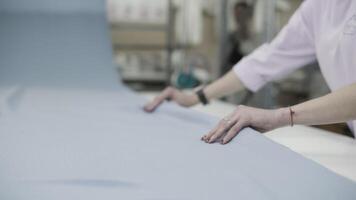 A textile worker is delicately handling fabric in a factory environment with precision and care video