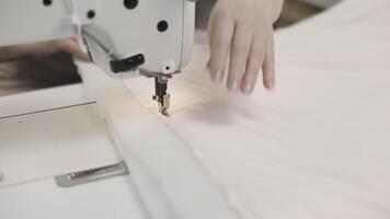 A seamstress is using a sewing machine to work on a fabric project with skill and dedication video