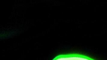 Green and orange scattering beam of light. Motion. Black background with a playing beam of light made in abstraction. video