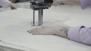 Craftsman operating industrial fabric cutting machine for precise pattern cutting video