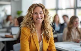 Smiling Woman In Yellow Blazer Sitting In An Office photo