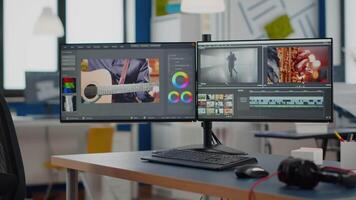 production studio with nobody in it and computer with two displays processing film montage in new software. Empty movie editing creative start up agency with no people video