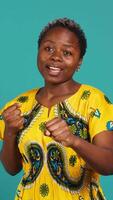 Vertical Strong rebel woman posing with clenched fists in studio, preparing for a fight and threatening with a protest symbol. Confident girl ready to strike, aggressive conflict and violence. Camera A. video