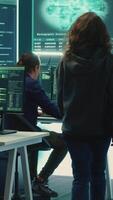 Vertical Governmental hackers team securing computer systems from cyber threats, working together in agency control room. Emphasizing encryption, online security and espionage against cyber attacks. Camera A. video