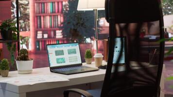 Empty home office setup showing documents and financial reports on laptop, desk used for a person to work on market analytics and accountancy. Organizational budget balance analysis. video