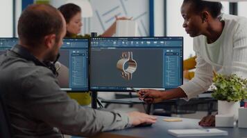 Diverse team discussing about industrial project using dual monitors setup to desing 3D gears and metalic clamp in CAD software. Industrial engineer and african manager working in creative office video