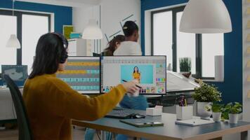 Graphic editor retouching photos of a client on performance PC with two displays setup. Woman retoucher working in photo editing software app sitting in creative agency office holding stylus pen video