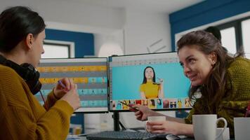Art director teaching retoucher employee how to color gread female portret using photo editing software. Graphic designers analysing client assets from displays and taking notes in creative agency video