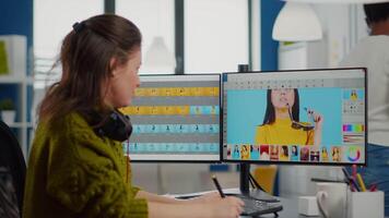 Freelancer retoucher woman working on computer with photo editing software. Professional graphic editor retouching assets of client with stylus pencil and two monitors in creative multimedia company video
