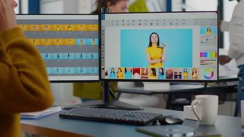 Professional photographer sitting at desk putting on headphones for listening music using PC in photo studio retouches. Content creator doing portrait retouching using post production software video